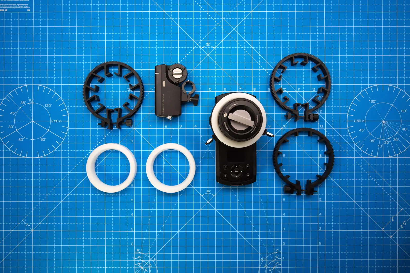 Wireless follow focus motor, gears and lens accessories laid out for a camera hire kit check