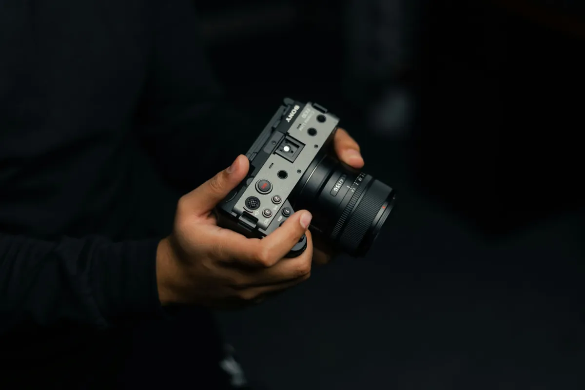 Sony FX30 Cinema Line camera held in one hand, fitted with a compact Sony E 15mm f/1.4 G lens