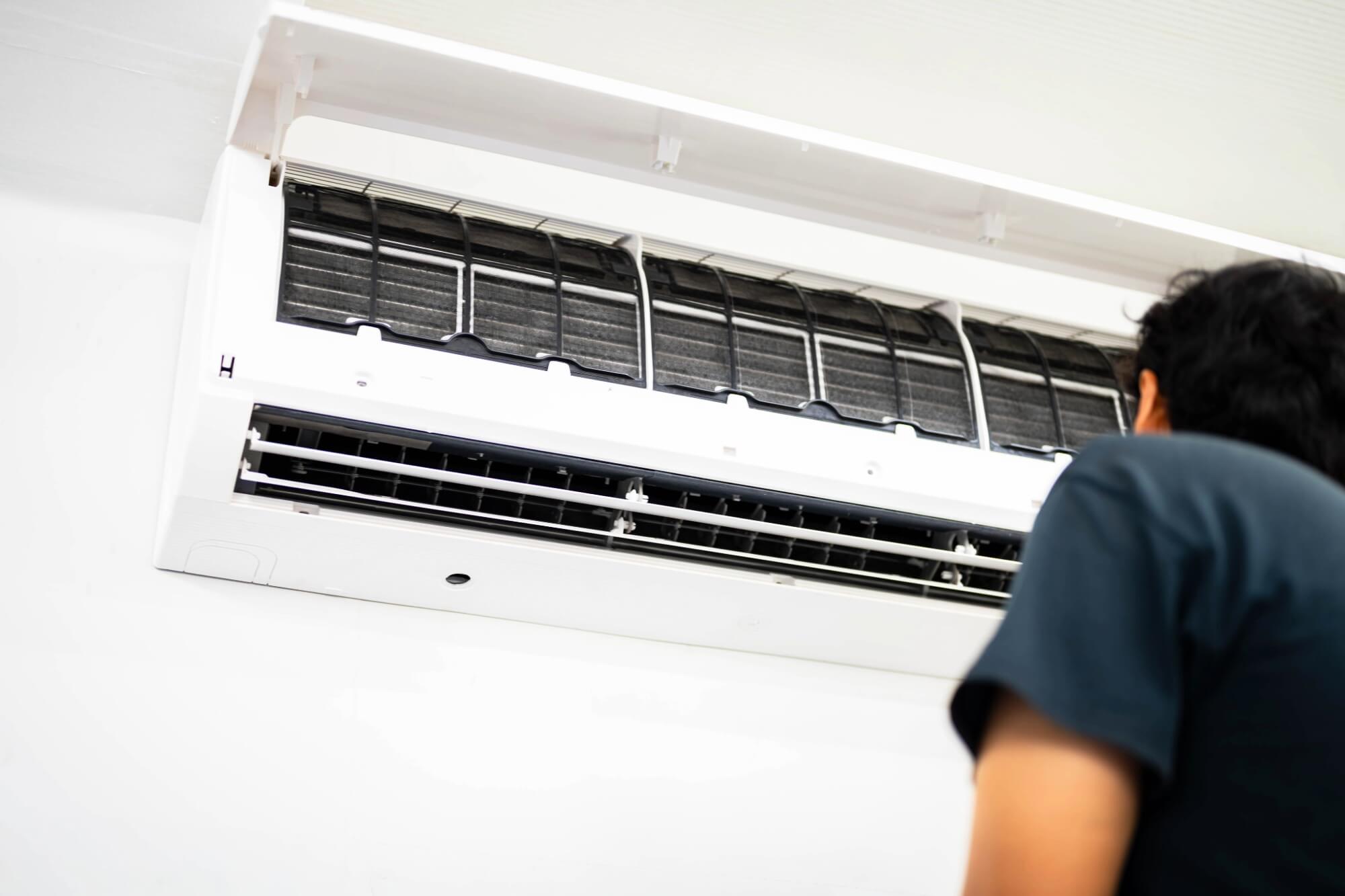 Homeowner looking at open split ac unit