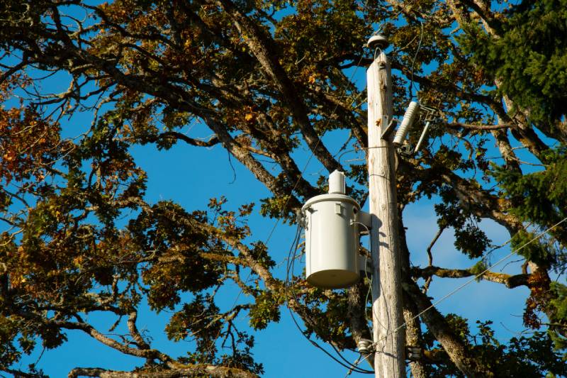Electrical transformer on utility pole, blue sky