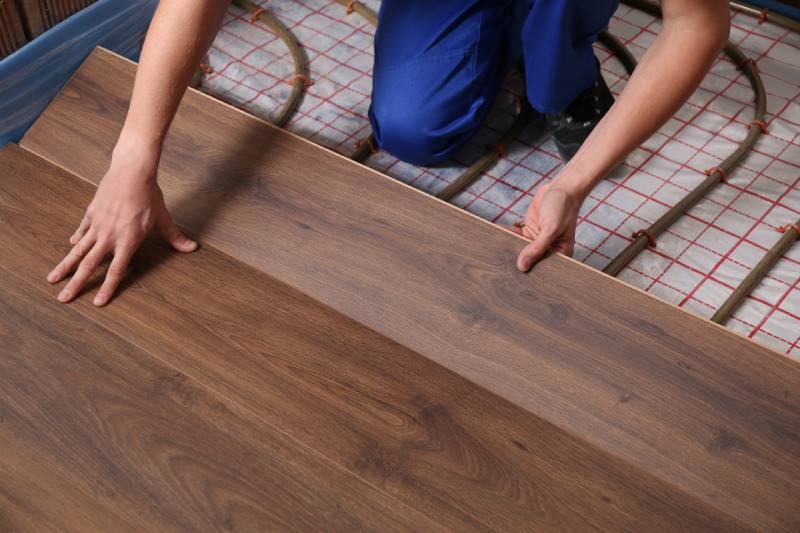 Installing wood flooring over radiant heating system.