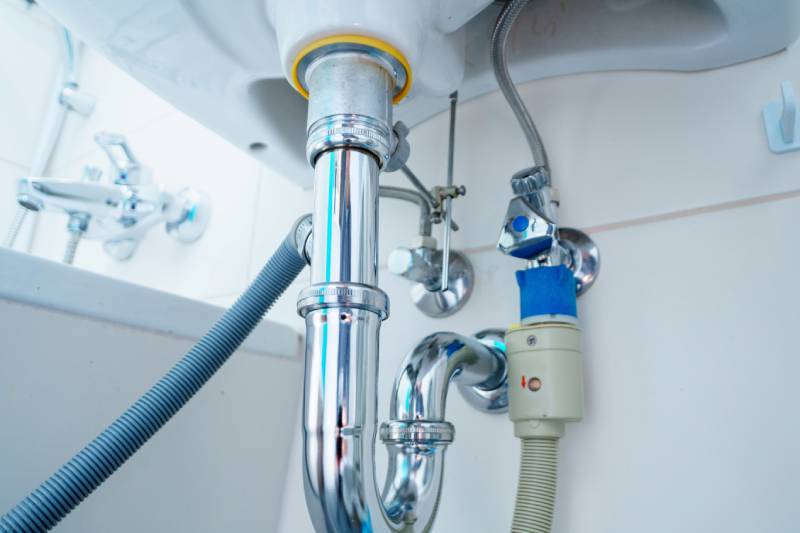 Shiny chrome pipes under sink.