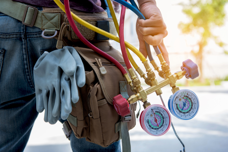 Technician holding HVAC gauges.