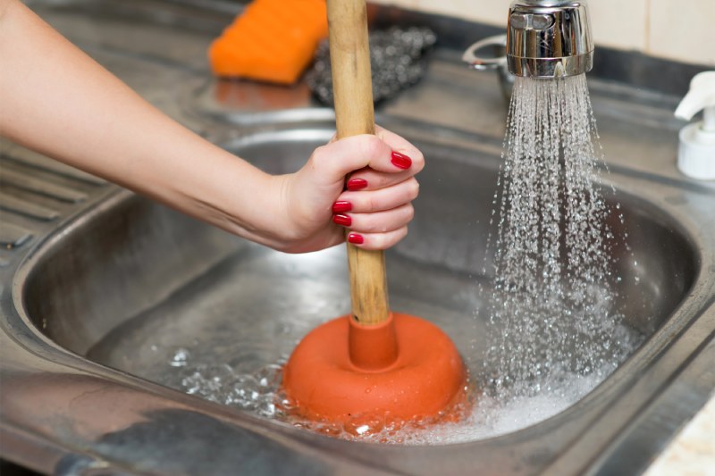 Woman plunging kitchen sink
