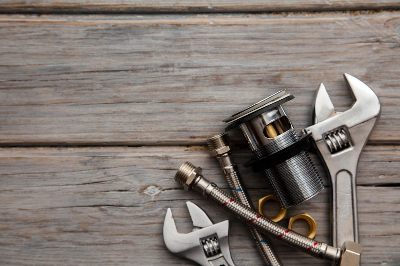 Plumbing tools on wooden surface
