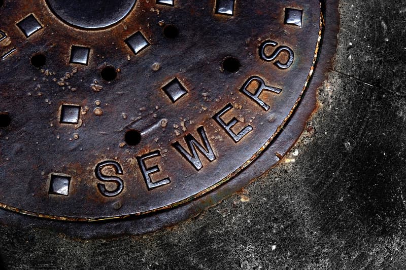 Rusty sewer cover on concrete.