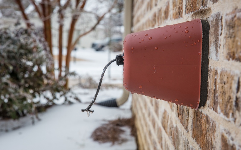 Covered outdoor faucet with ice and snow.