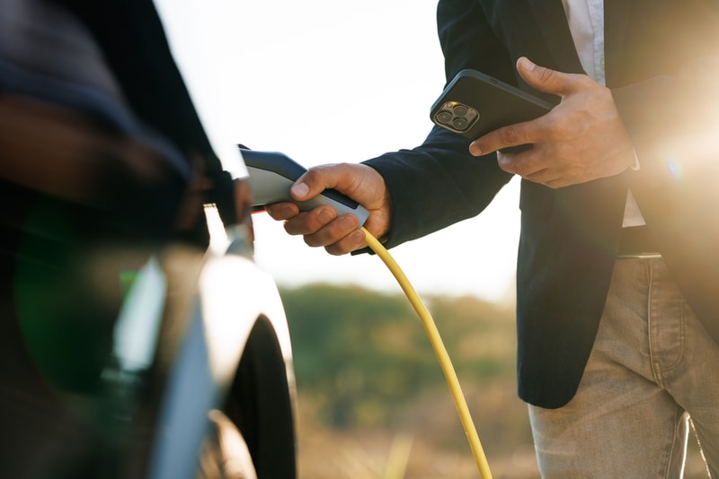 Man charging EV via app.