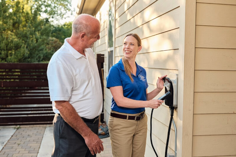 A technician demonstrates EV charger to a customer.