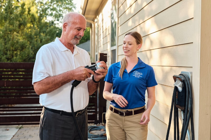 Two people examining an EV charger.