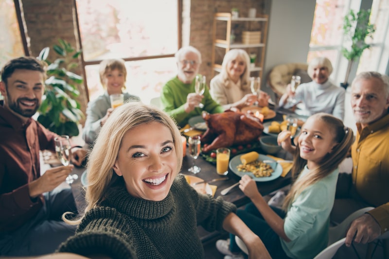 Family smiling at Thanksgiving dinner table