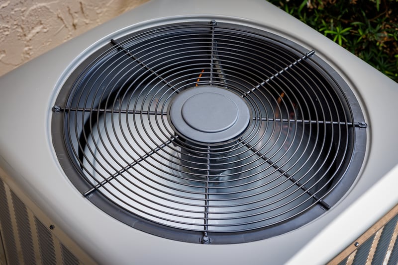 Closeup of outdoor AC unit fan grille.