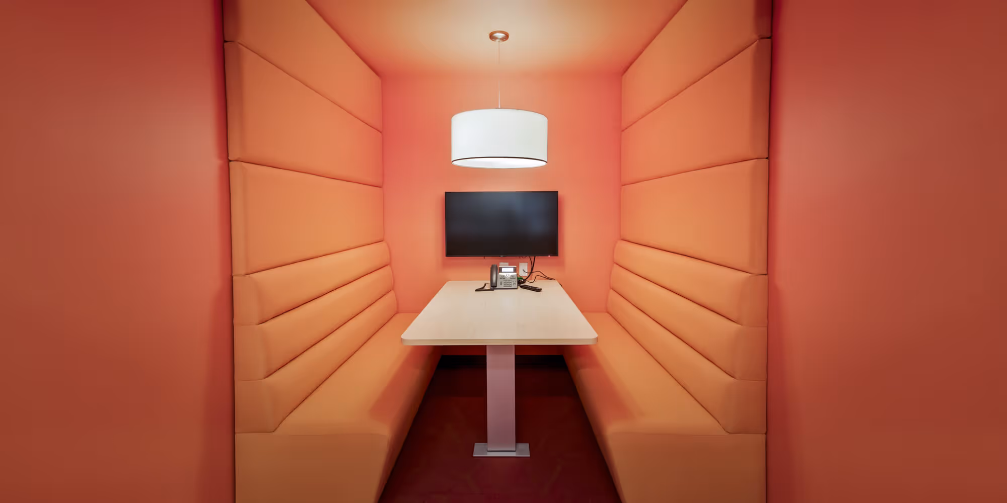 Booth seating with a dramatic orange background