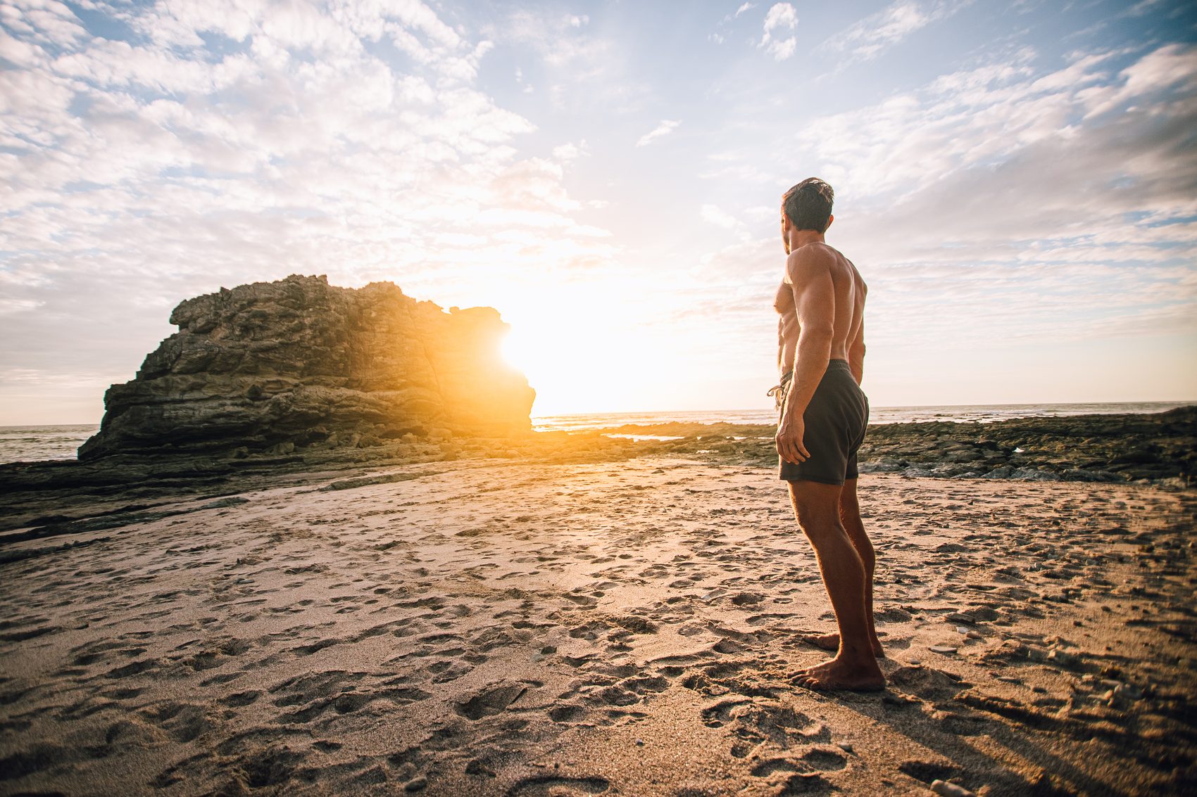 Paul Saladino standing on a beach at sunrise, facing the low sun