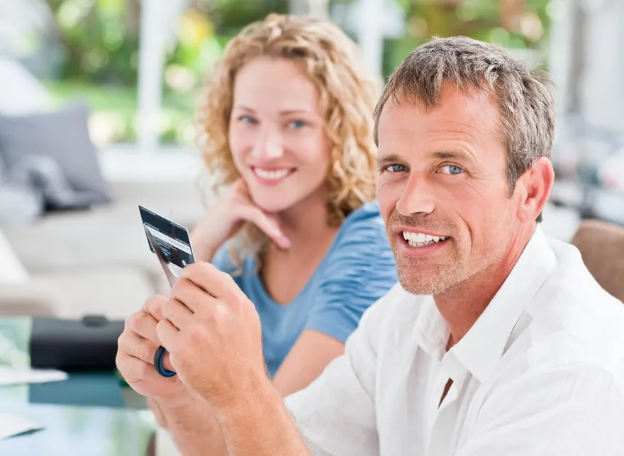 Smiling couple holding up a cut credit card