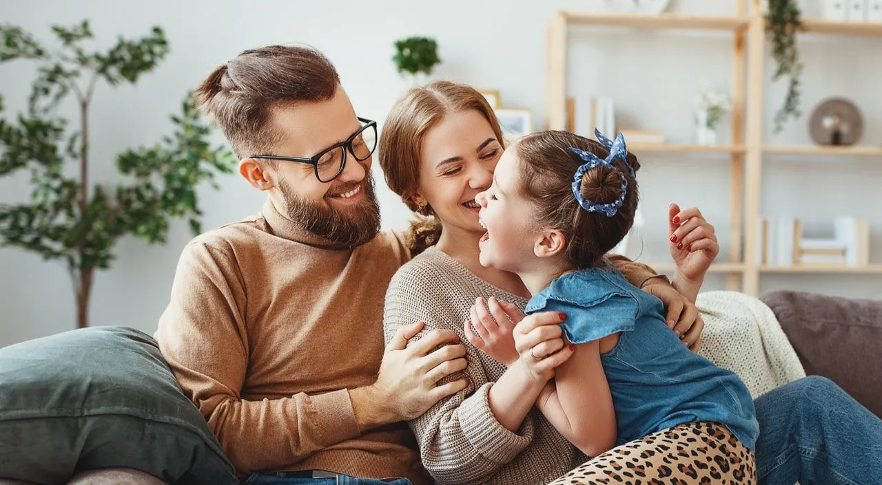 Family smiling sitting on couch