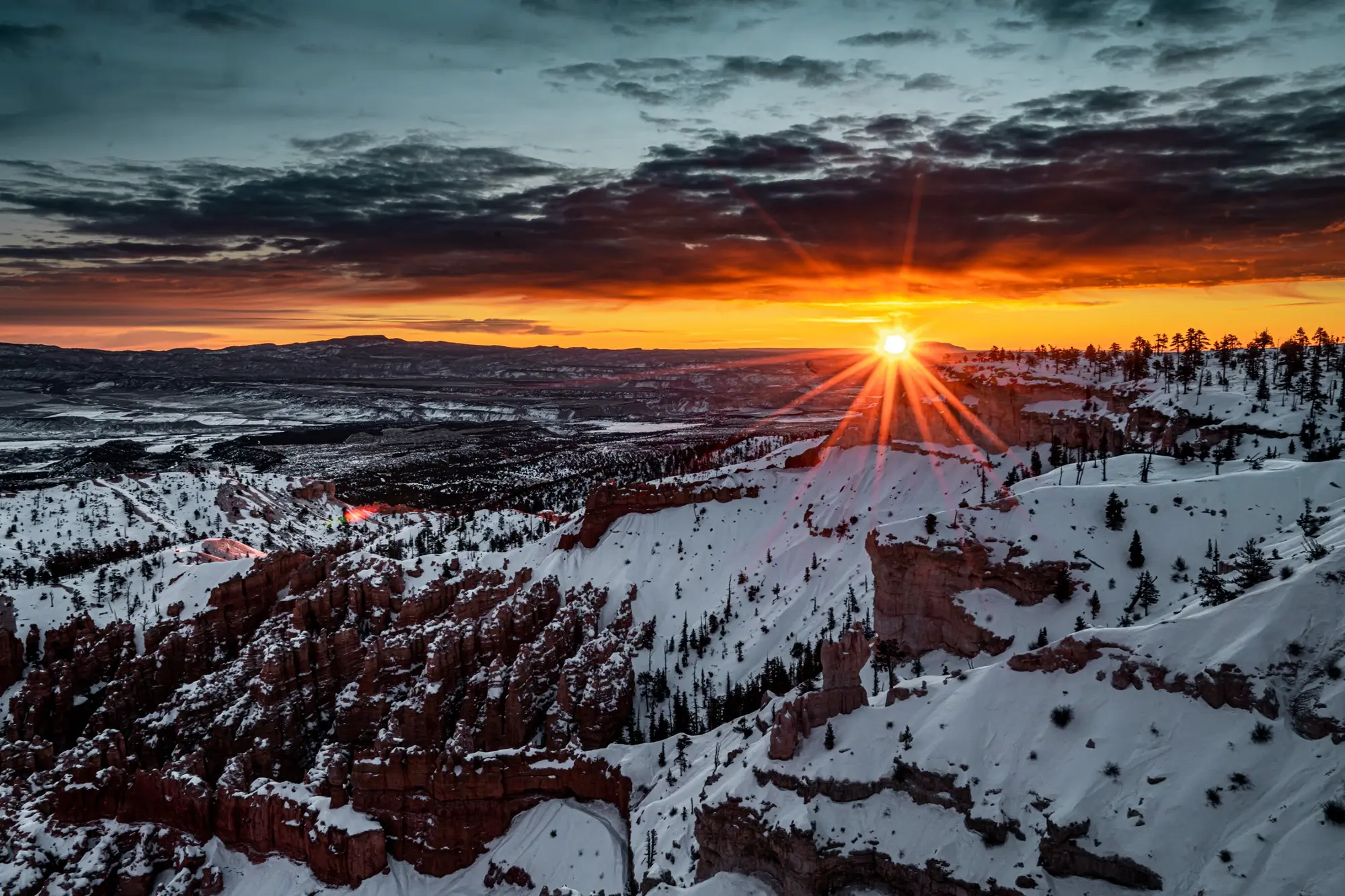 Dramatic summer sunset over a snowy canyon landscape, symbolizing how increased sunlight highlights dust and dirt buildup during North York’s long summer days.