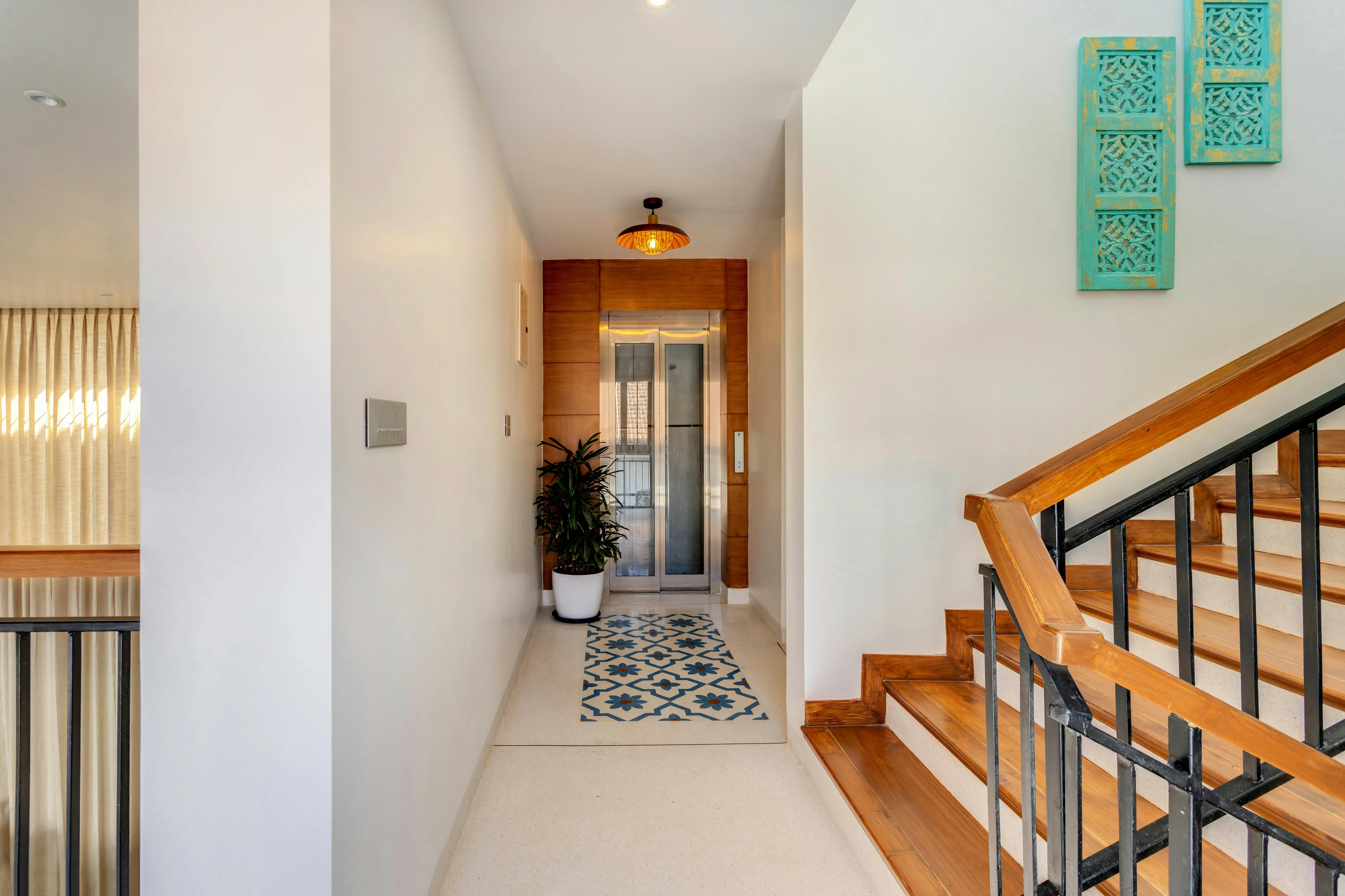Bright and tidy entryway with a staircase, indoor plant, and natural light, showcasing a clean and welcoming hallway for Toronto home staging.