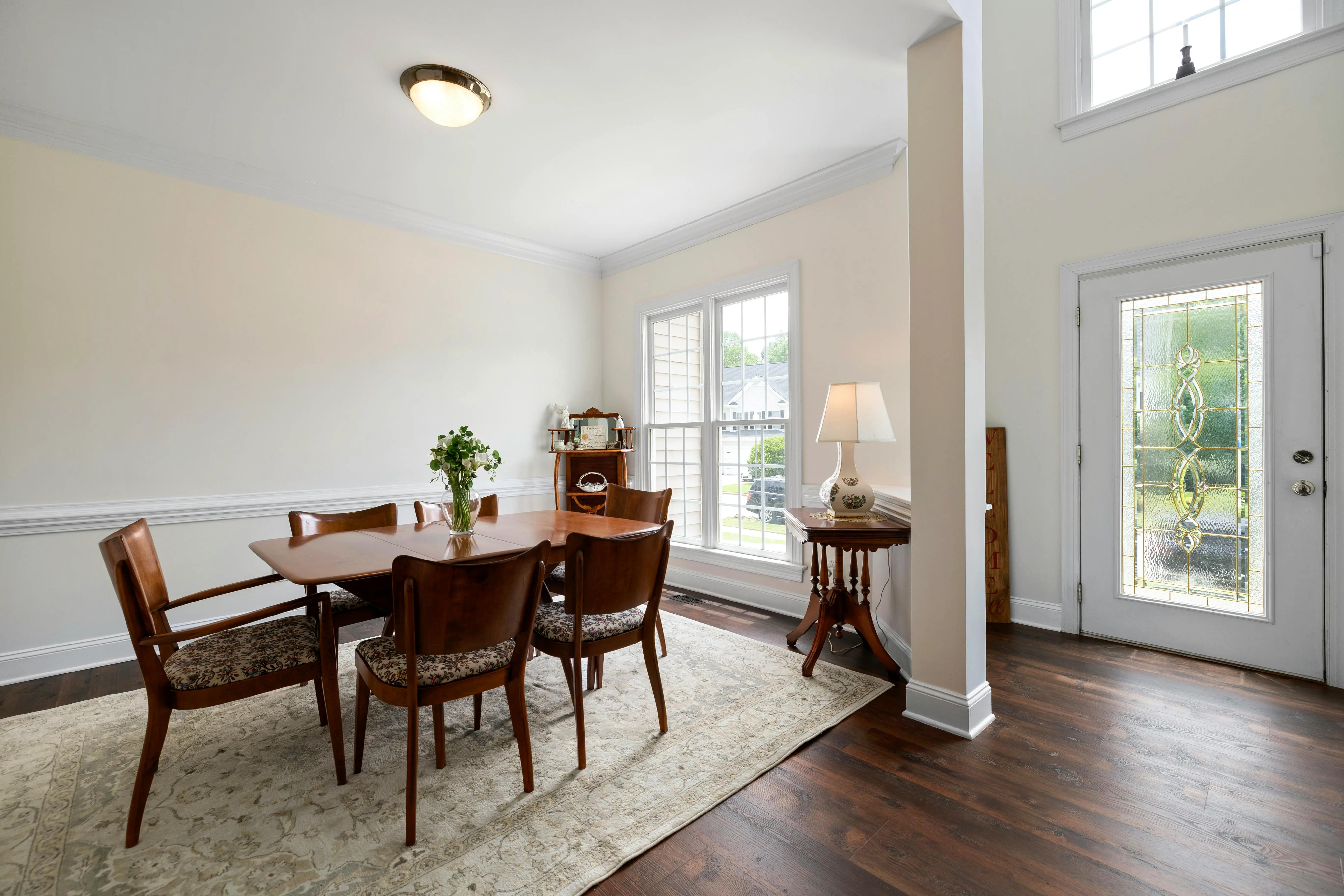 Bright dining room with a wooden table, chairs, and natural light from large windows, illustrating a clean and decluttered living space for Toronto home staging.