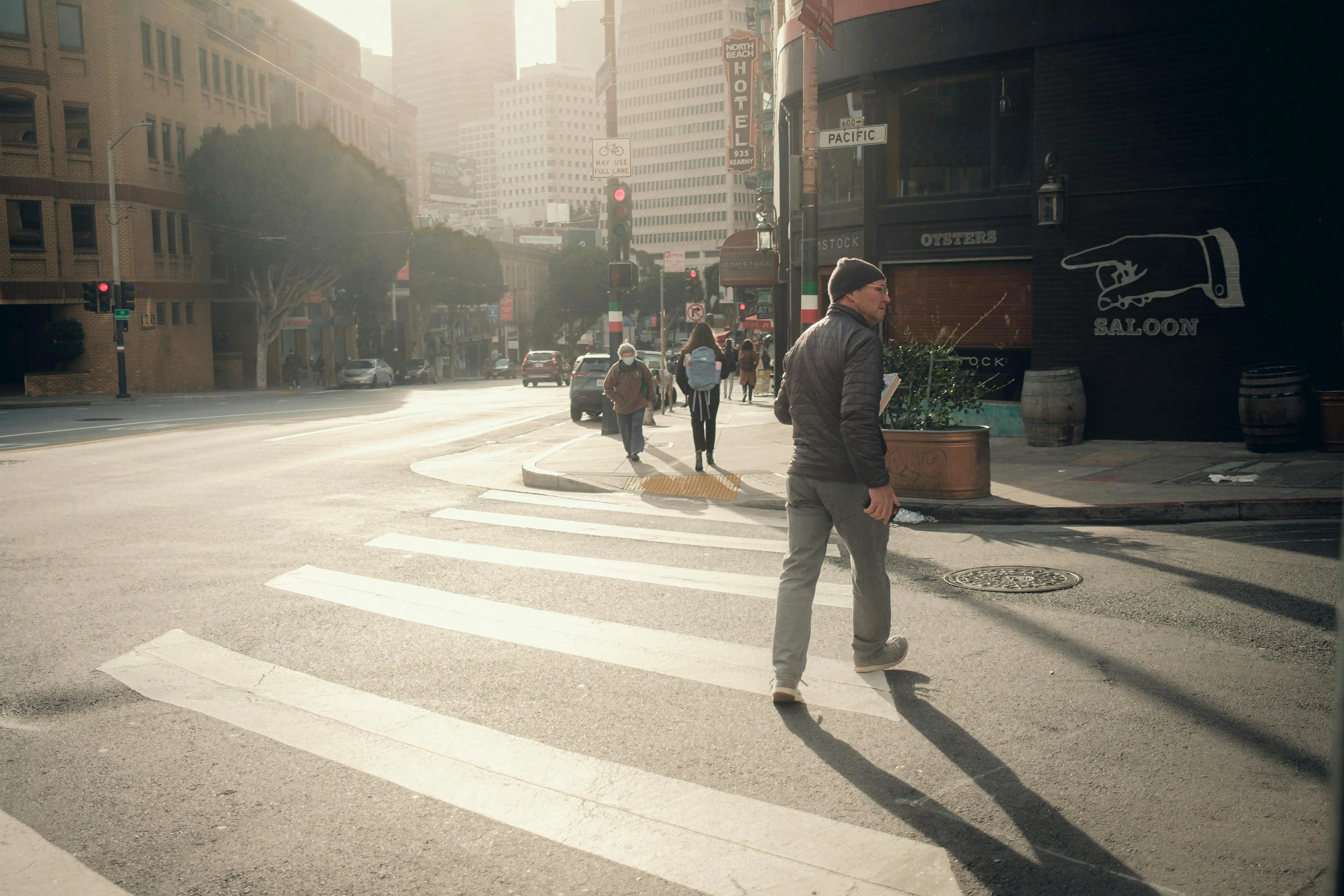 Busy city crosswalk scene with pedestrians walking under morning sunlight, symbolizing the hectic pace of Toronto life and why homeowners may need professional cleaning services.