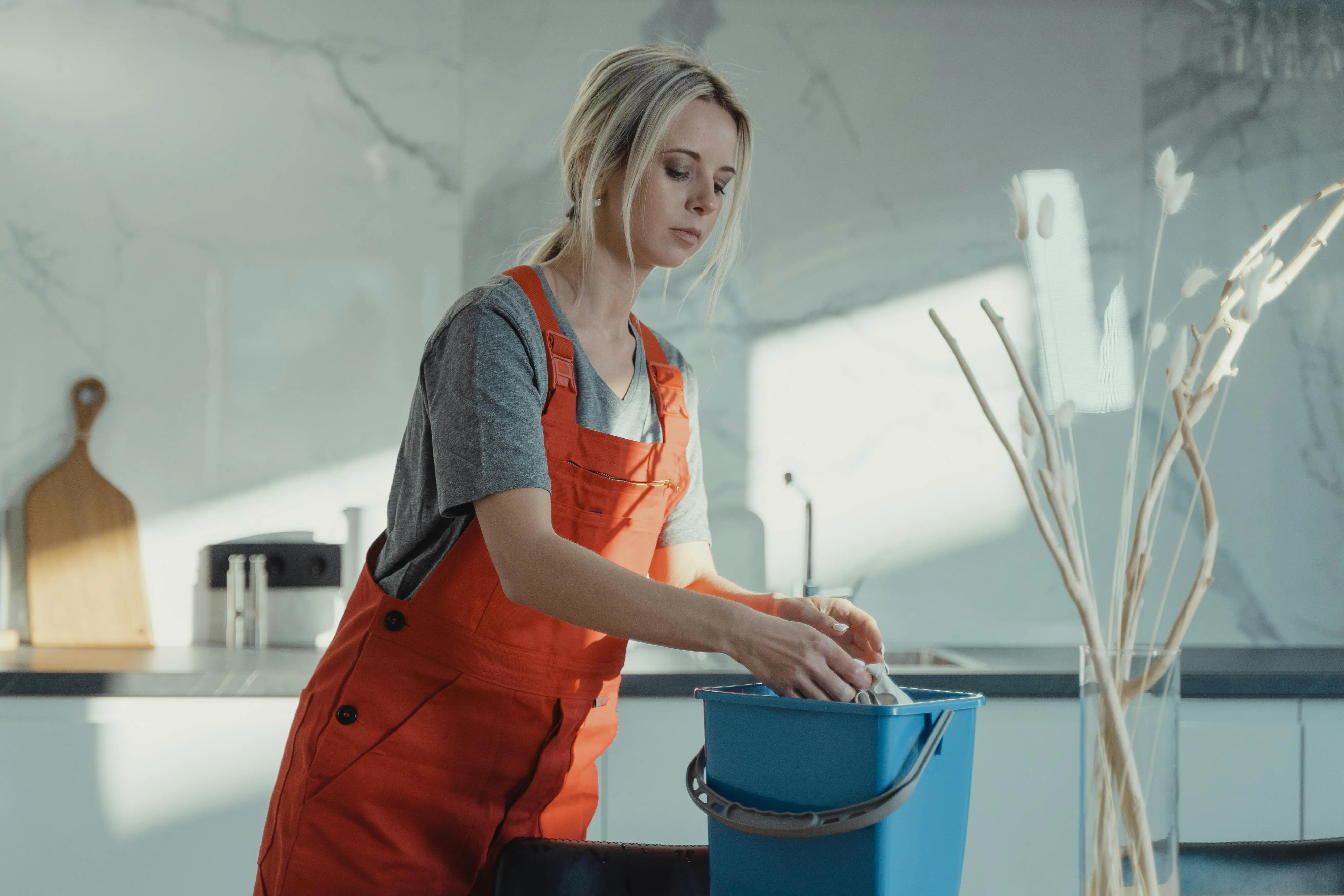 Woman in apron preparing mop bucket for deep cleaning — professional cleaning services for budget-conscious Toronto and GTA families.