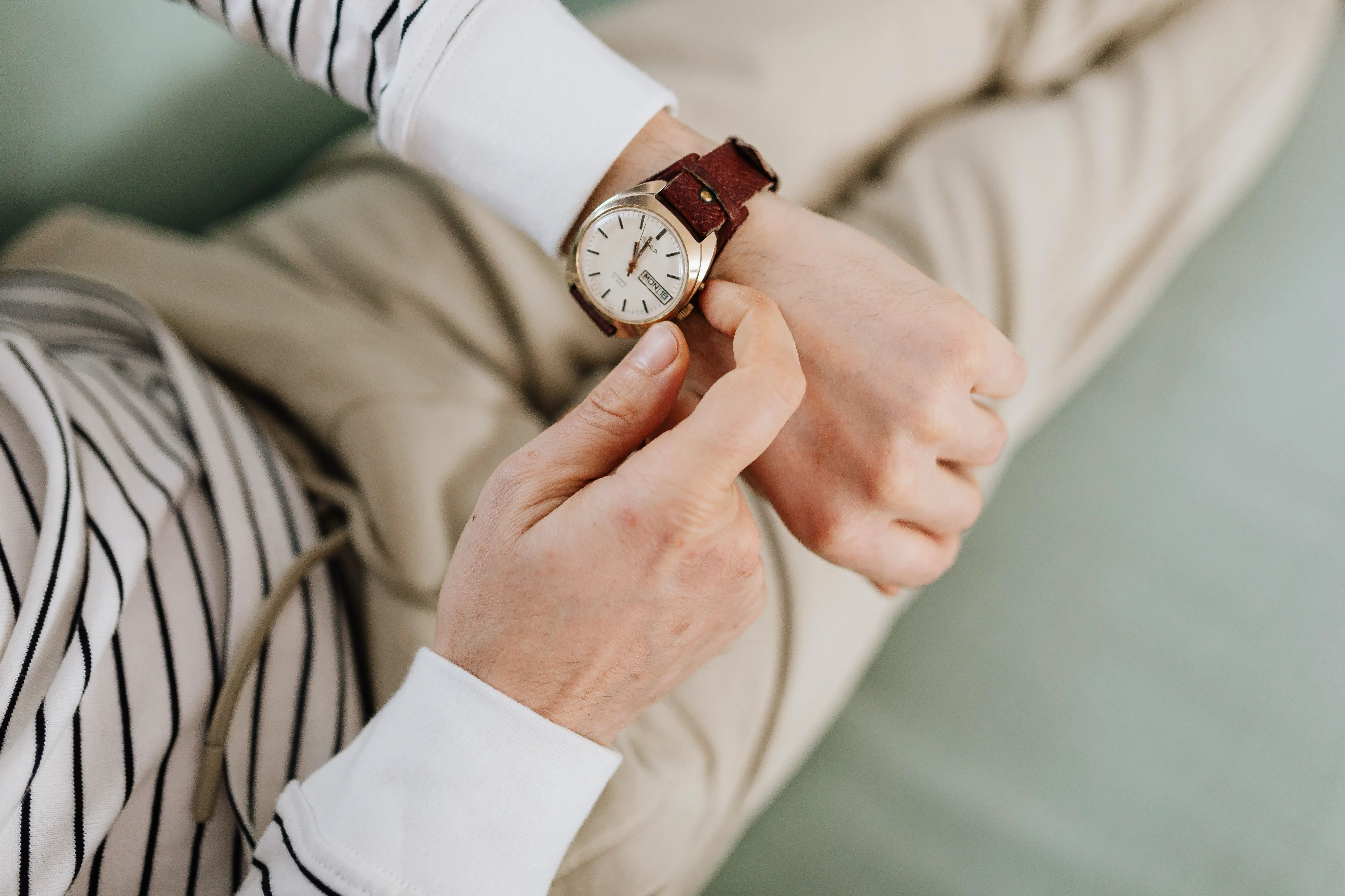 Checking a watch, timing how long a standard house cleaning takes