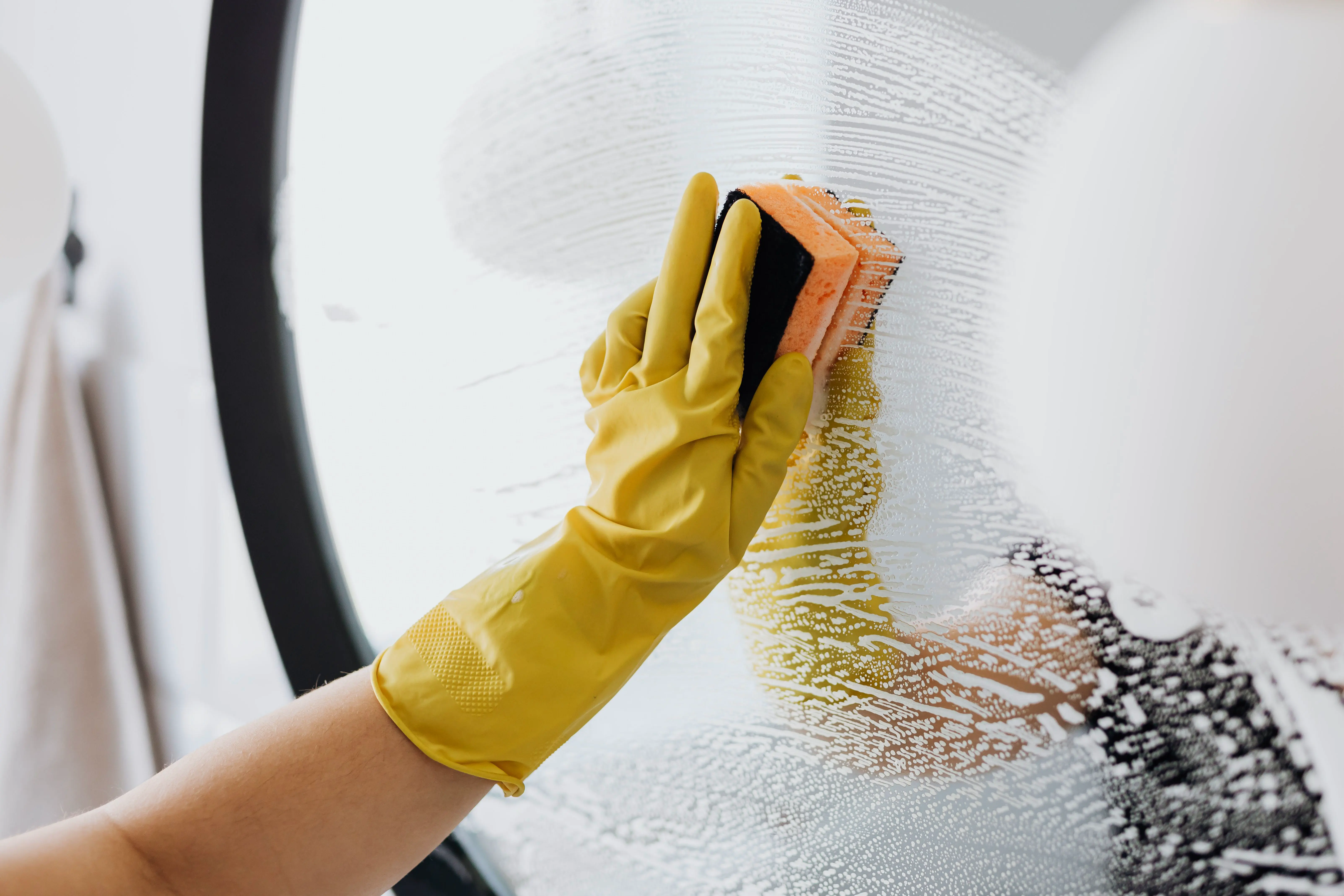 Standard house cleaning, wiping a mirror during regular home maintenance