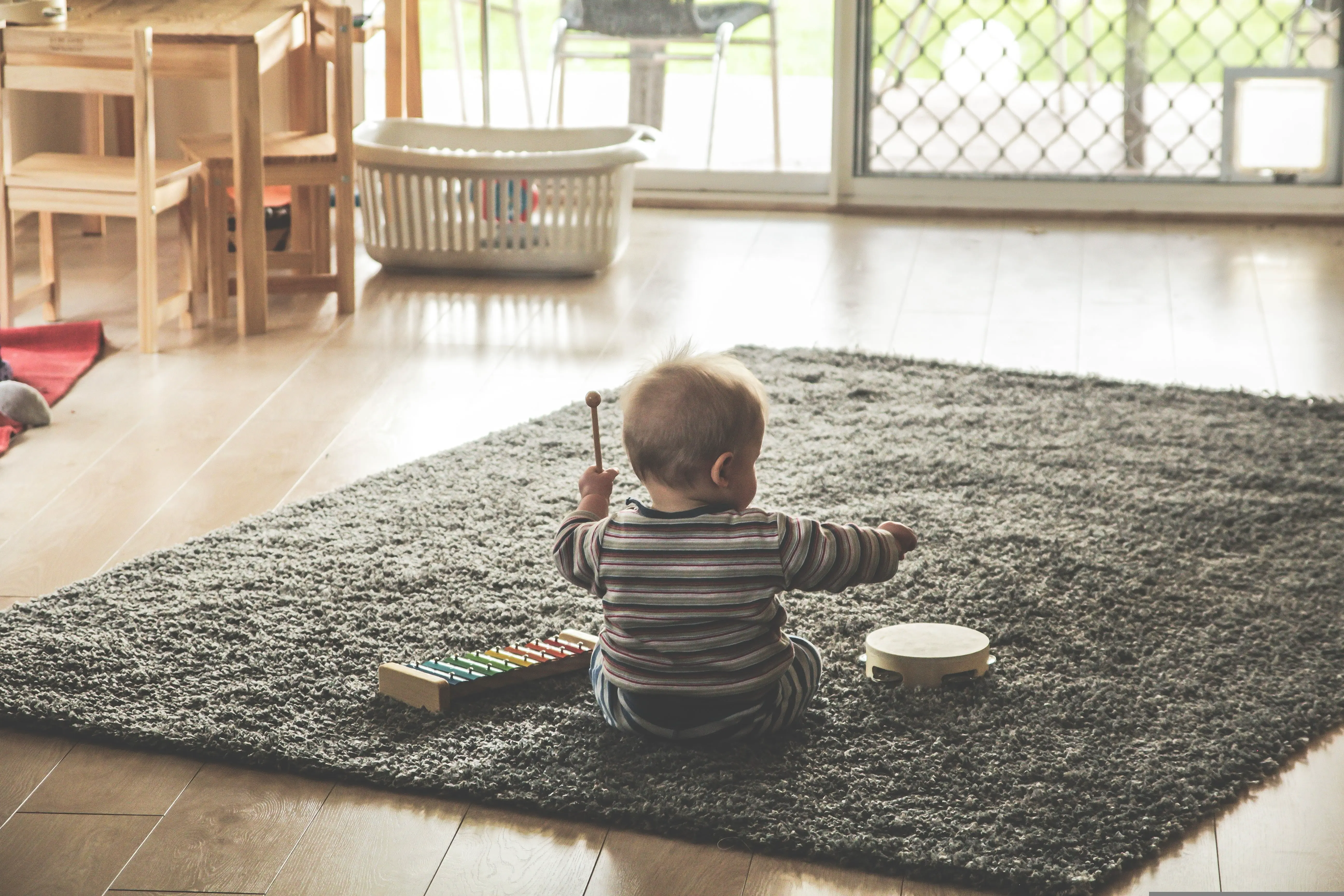 Toddler playing on a living room rug in a family home