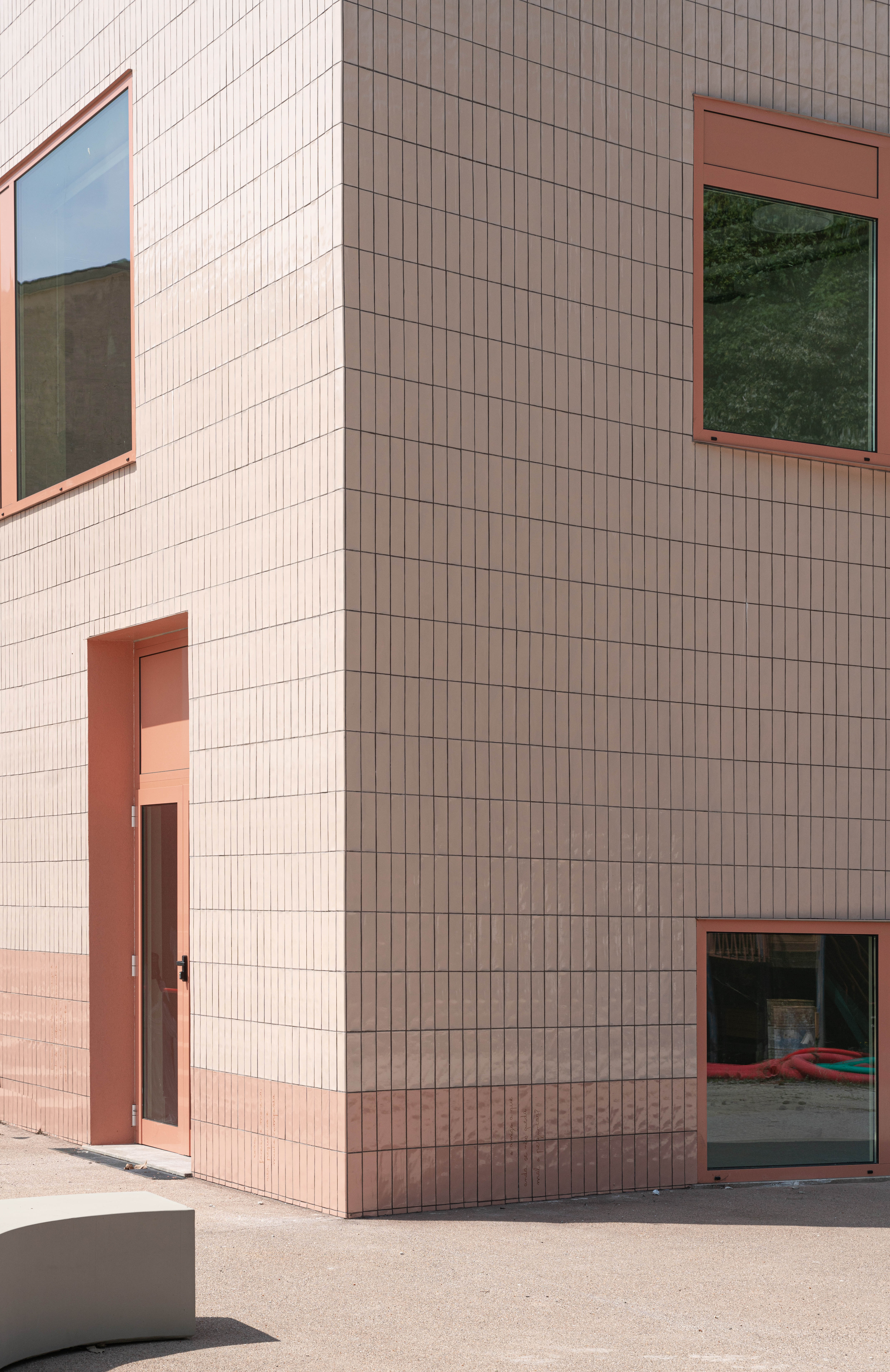 A terracotta colour boutique padel center in an industrial warehouse by Salto Studio in Lisbon