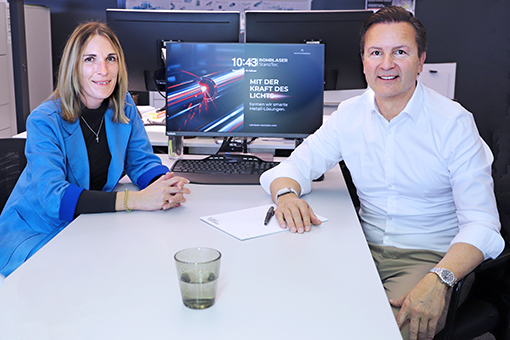 Frau und Mann sitzen an einem Bürotisch