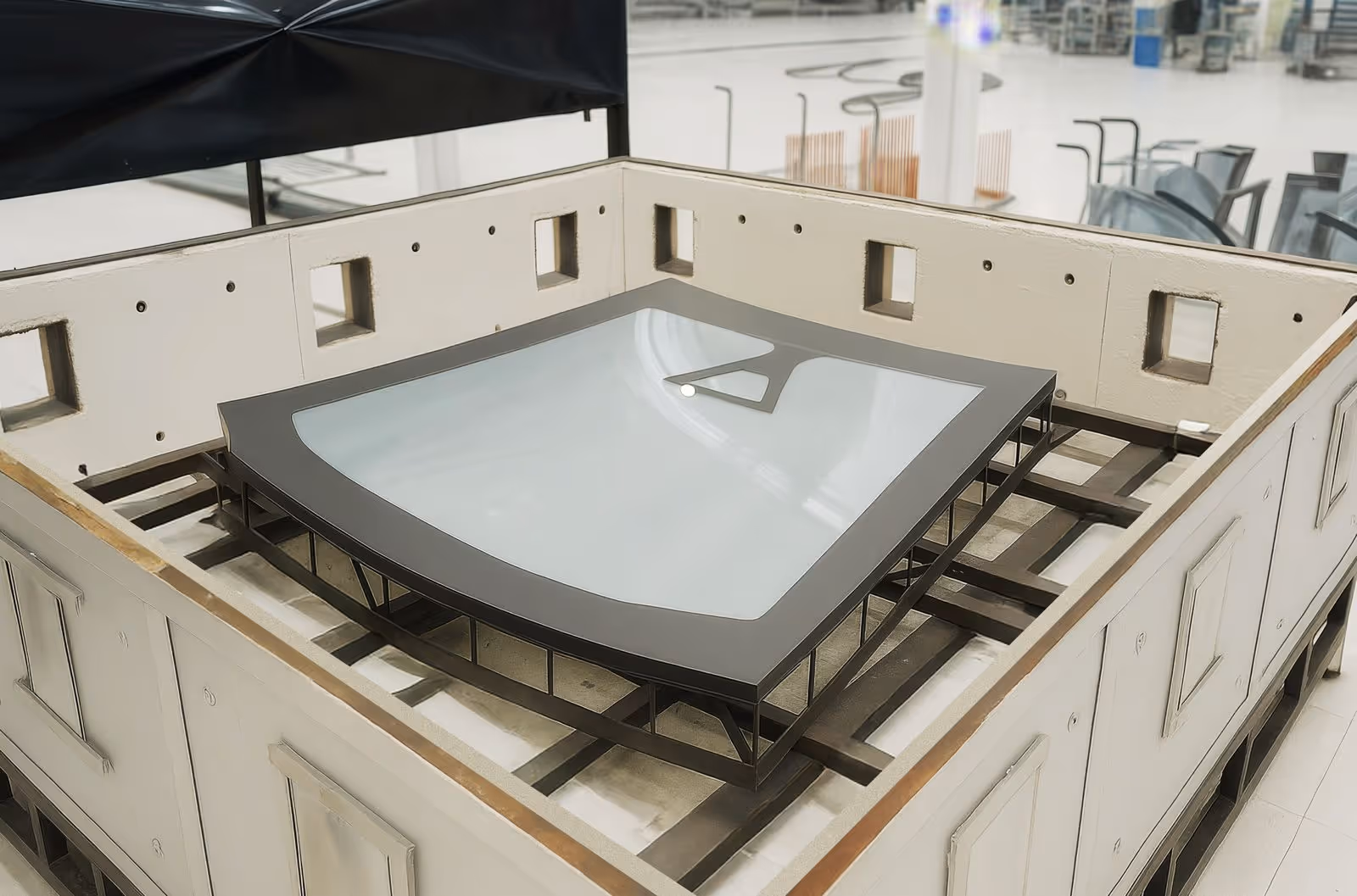 Protótipo de asa de avião ou componente aerodinâmico em bancada de testes dentro de laboratório industrial.