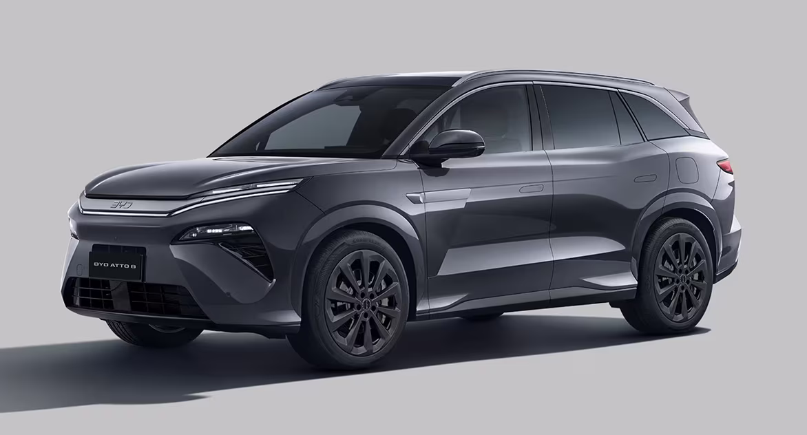 Carro SUV elétrico cinza metálico BYD Atto 3 visto de frente e lateral em estúdio.