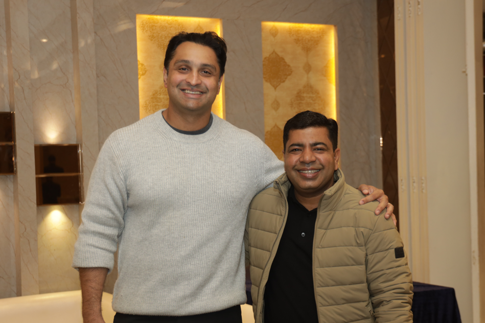 Two men standing together smilingAI-generated content may be incorrect.