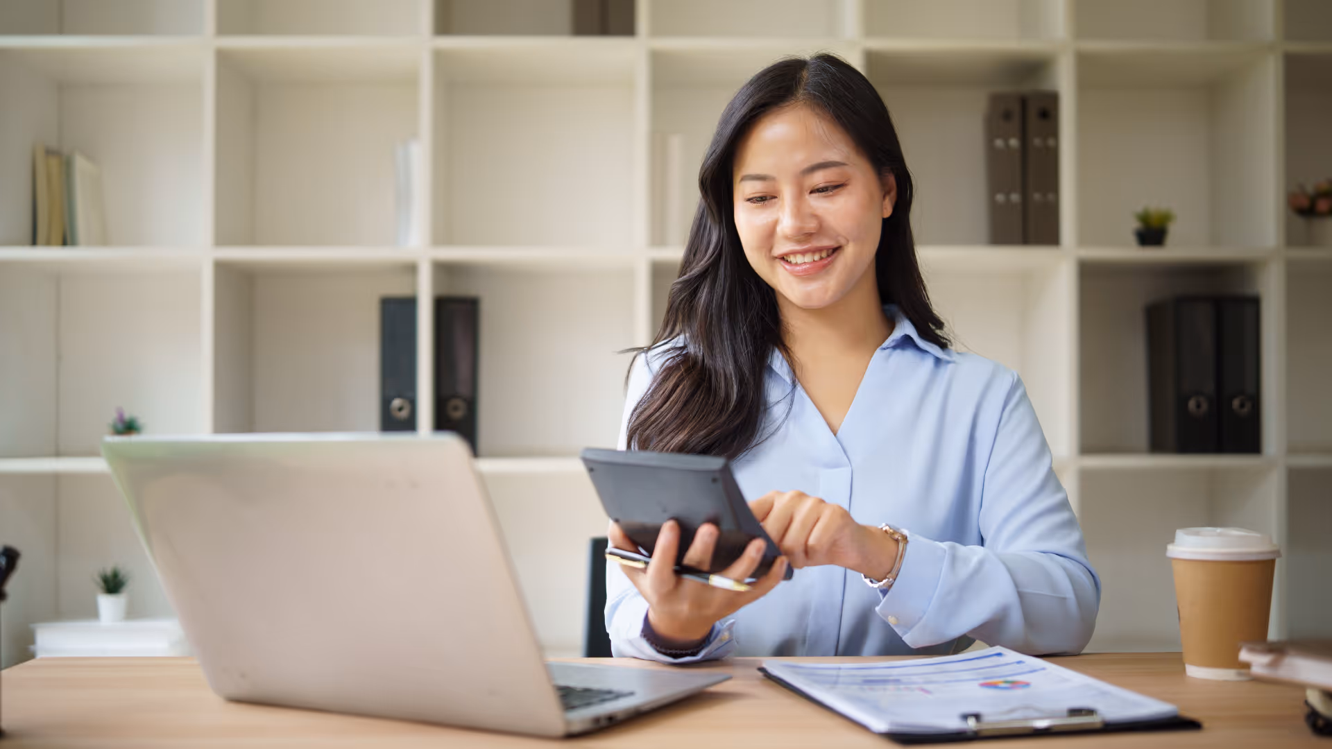 Small business owner reviewing finances with a bookkeeper using accounting software and financial reports