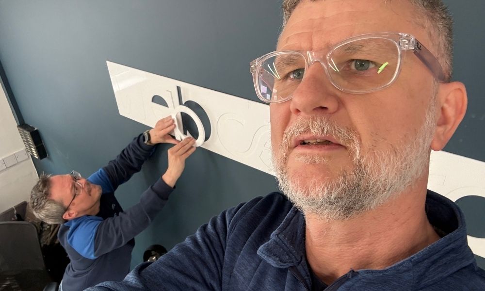 Steve and Paul in the new Brigg office, putting the Webcetera logo signage on the wall