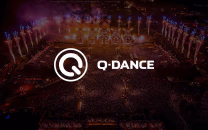 Q-Dance logo over aerial night view of a music festival with pyrotechnics and large crowd.