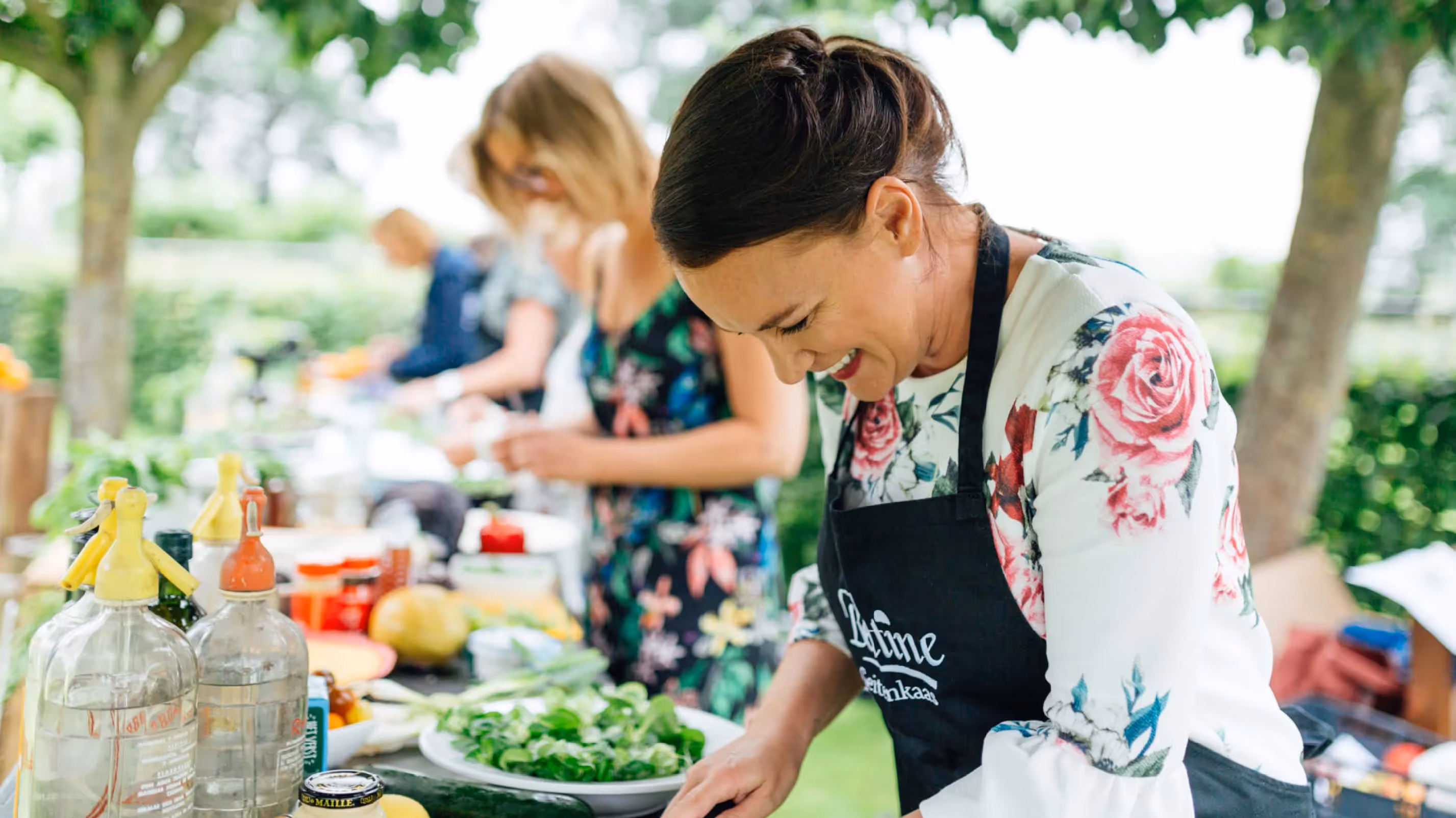 Een foto van dames die tijdens Saladay de gerechten met geitenkaas klaarmaken op een heerlijk zomerse dag.