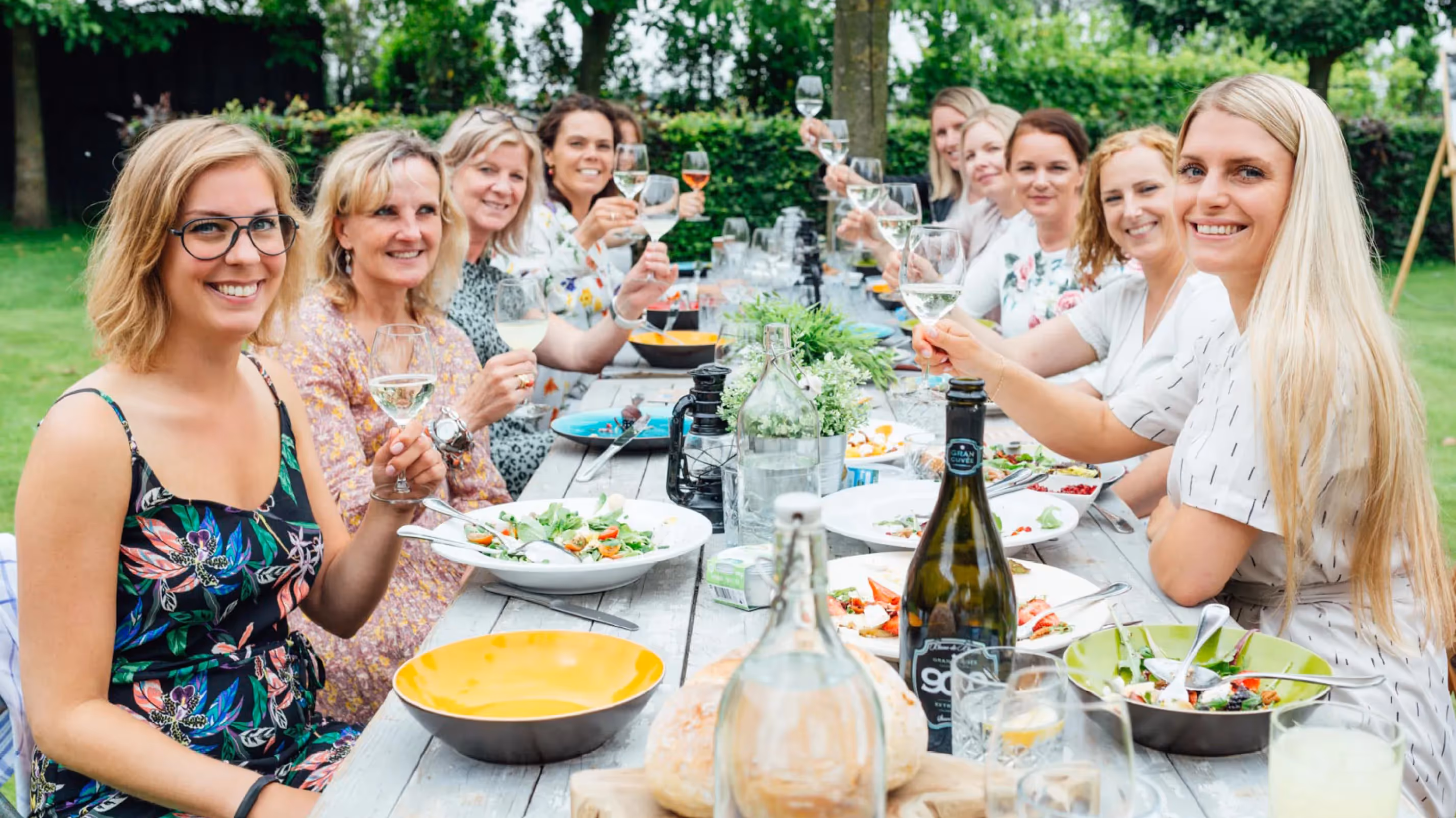 Een groepsfoto van alle deelnemers die toasten op de Saladay campagne.