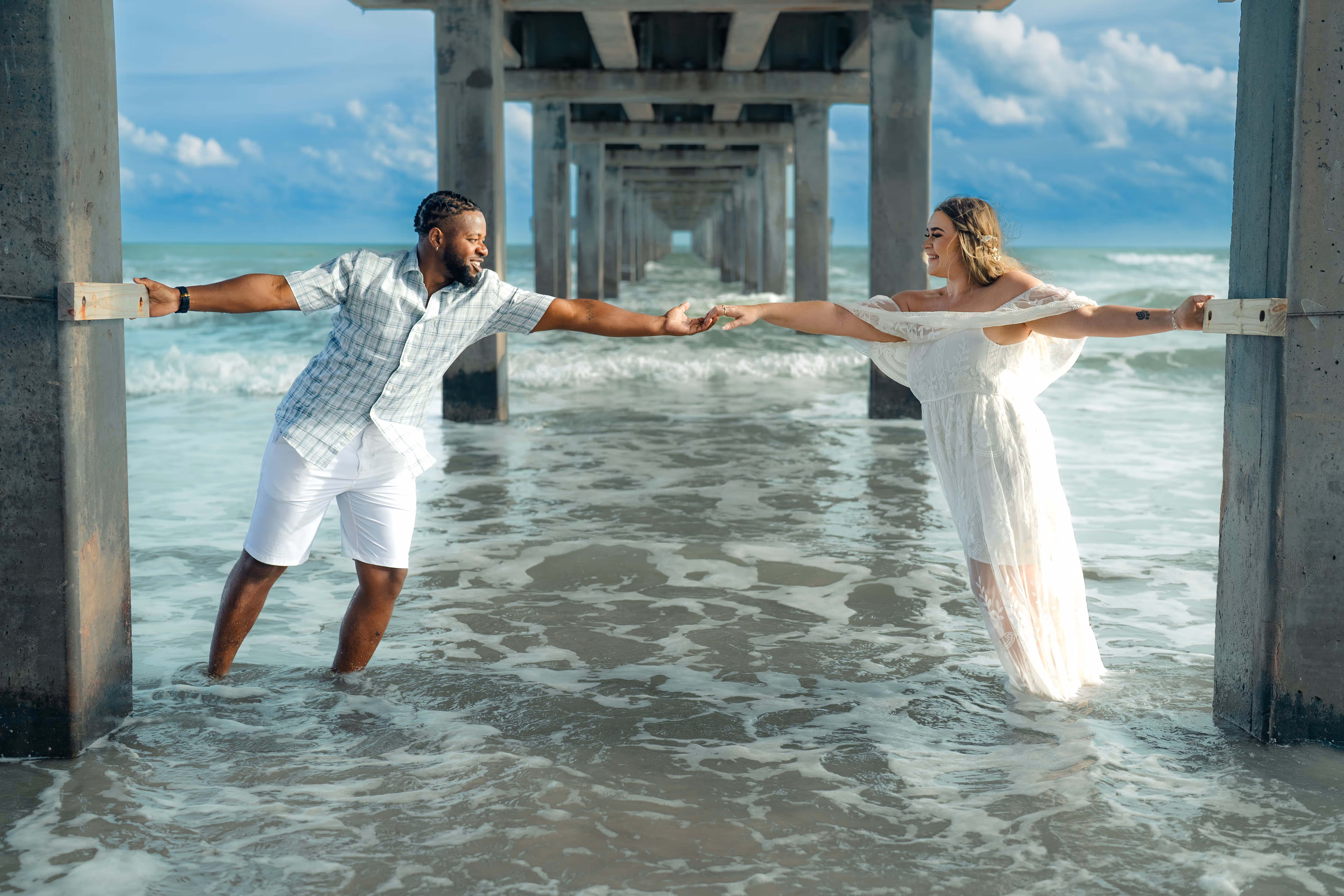 An engaged couple holding hands on the beach photography