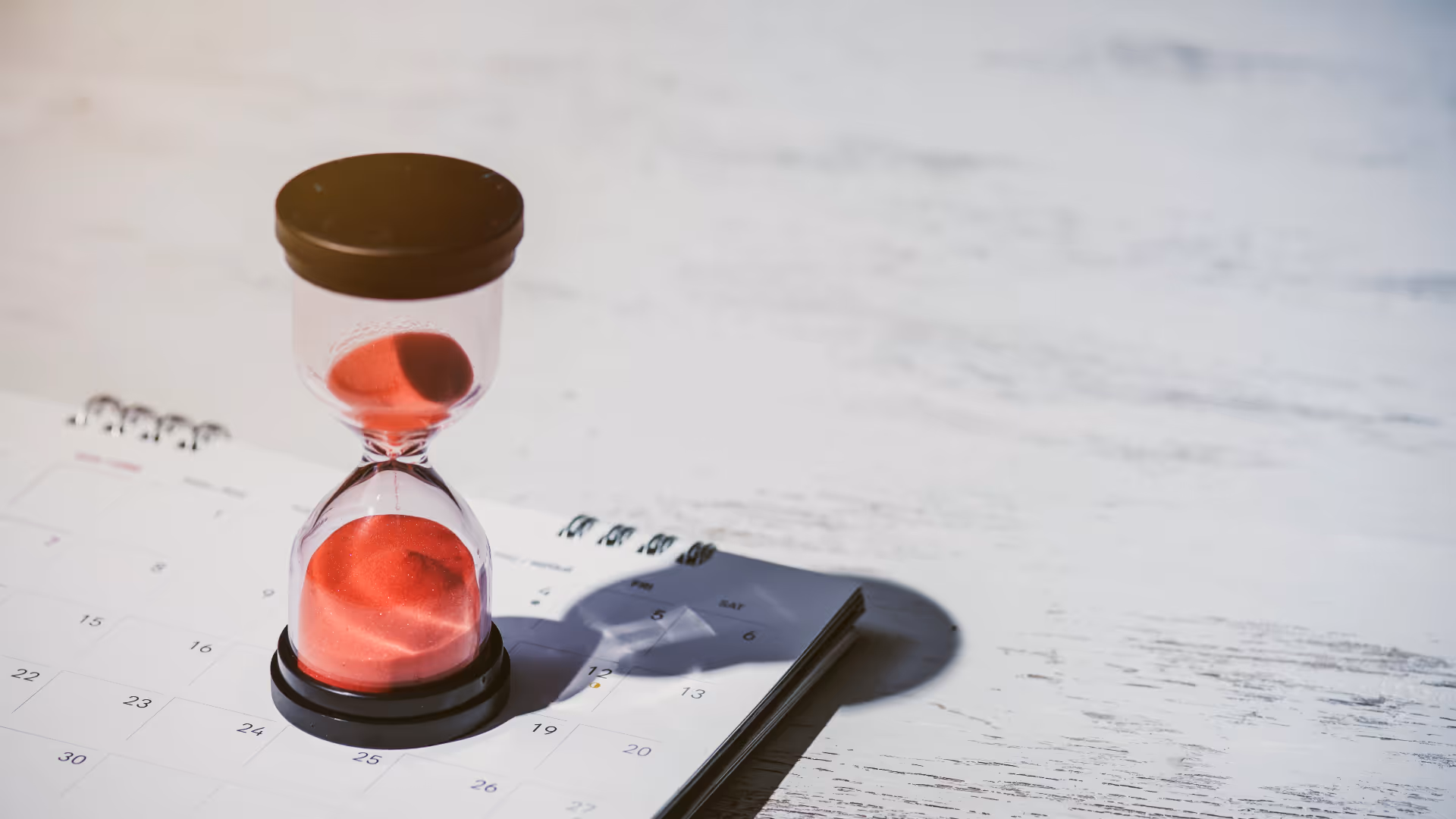 Hourglass and calendar on table