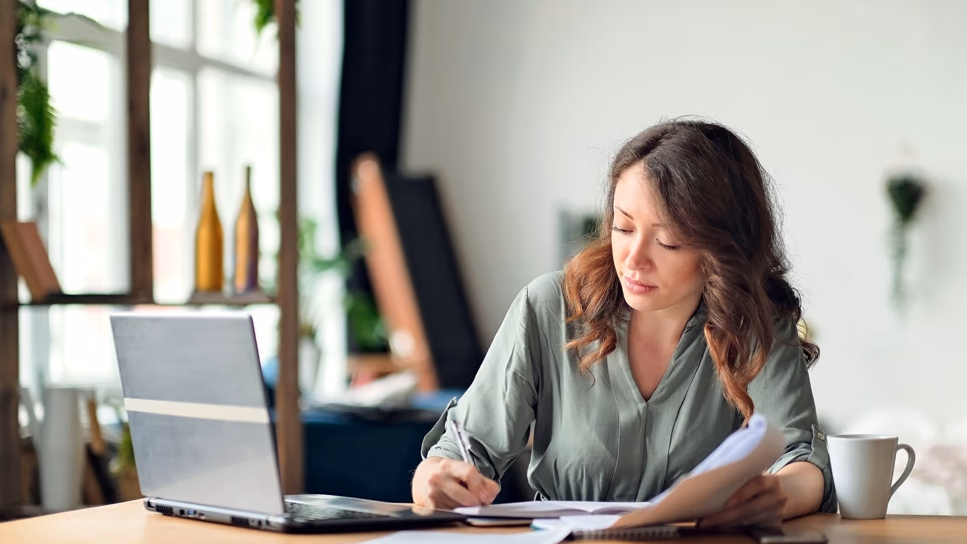 Young woman working from home office using laptop and the internet.