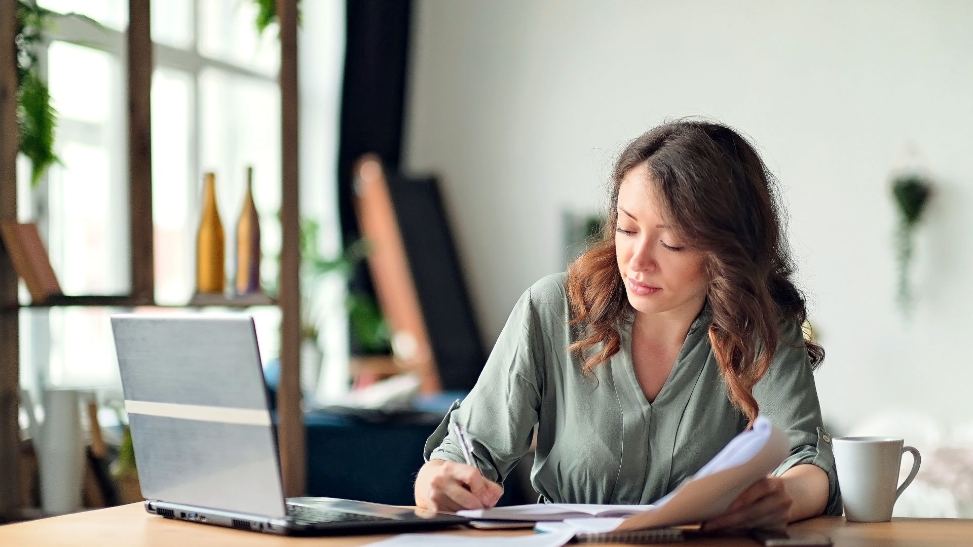 Young woman working from home office using laptop and the internet.