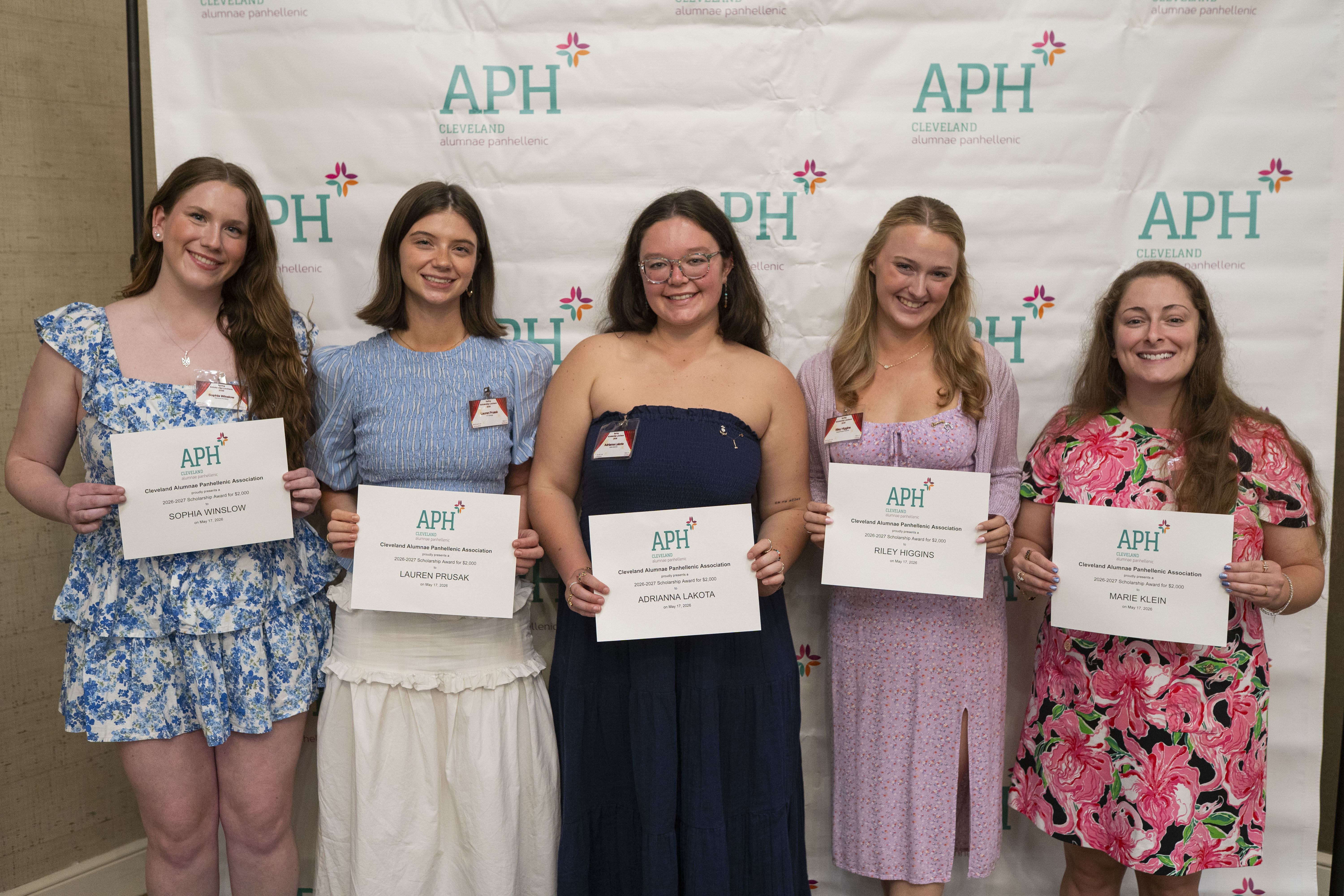 Past scholarship recipients holding up plaques