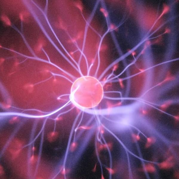 Illustration einer Nervenzelle mit verzweigten Synapsen und elektrischen Impulsen.
