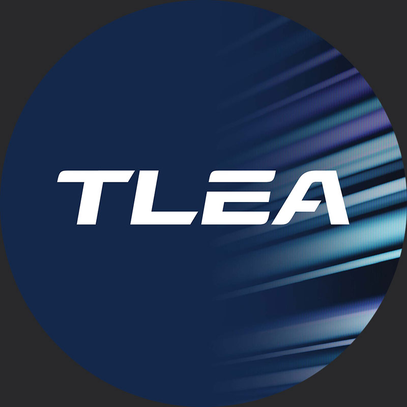 Navy circle containing TLEA logo in centre, with wordmark logo reversed out. 