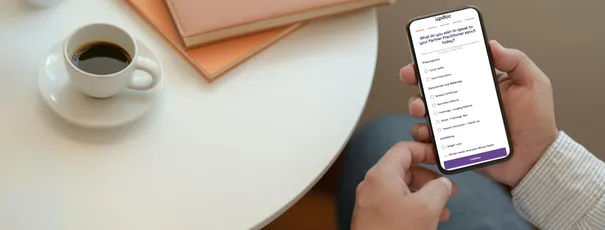Hands holding a phone showing the Updoc consult request form to book an Updoc appointment