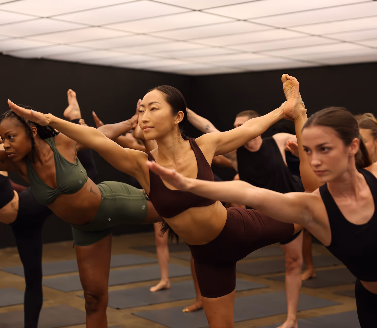 Group of diverse women practicing yoga balance pose in fitness studio