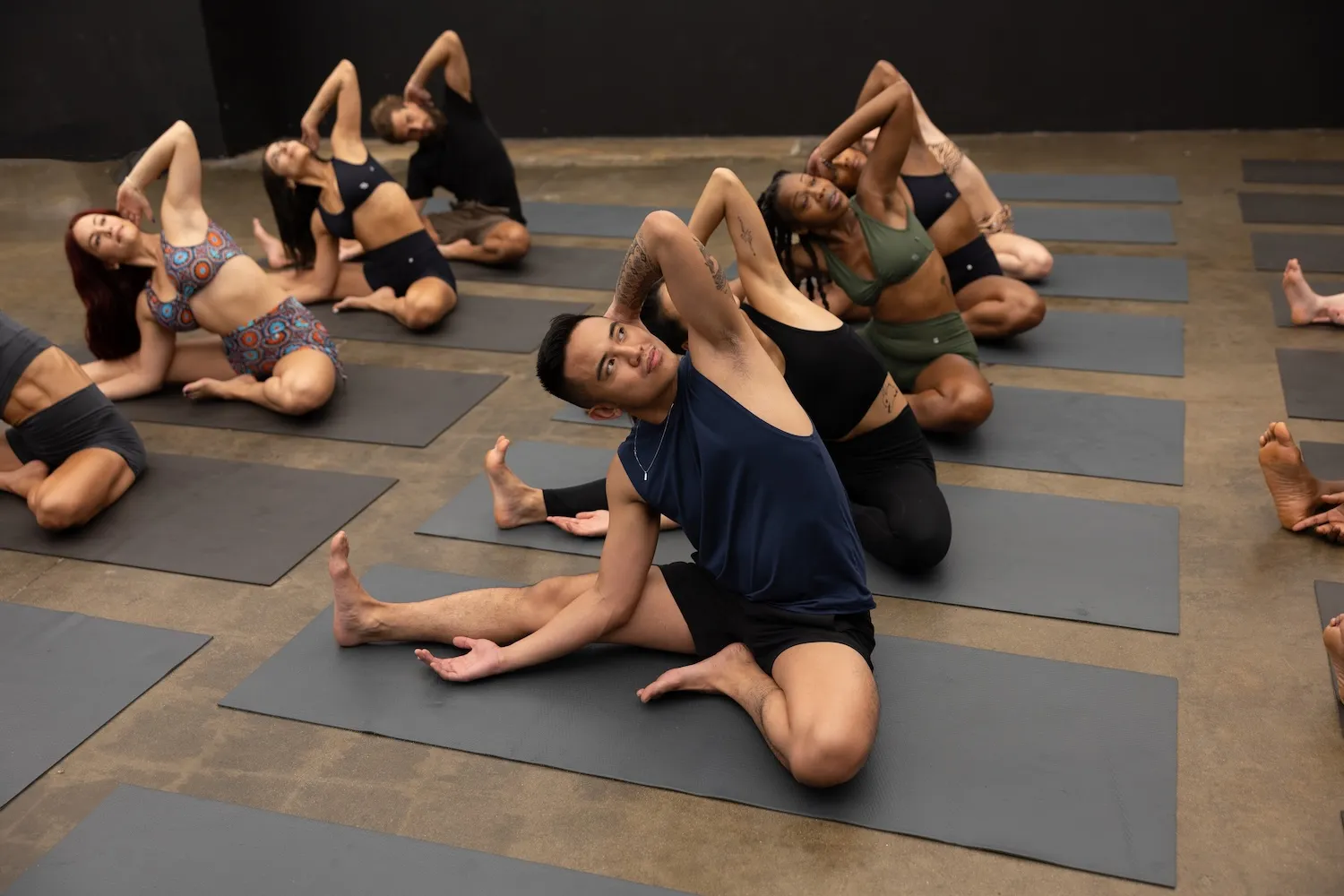 Group yoga class stretching on mats in coordinated side bend pose