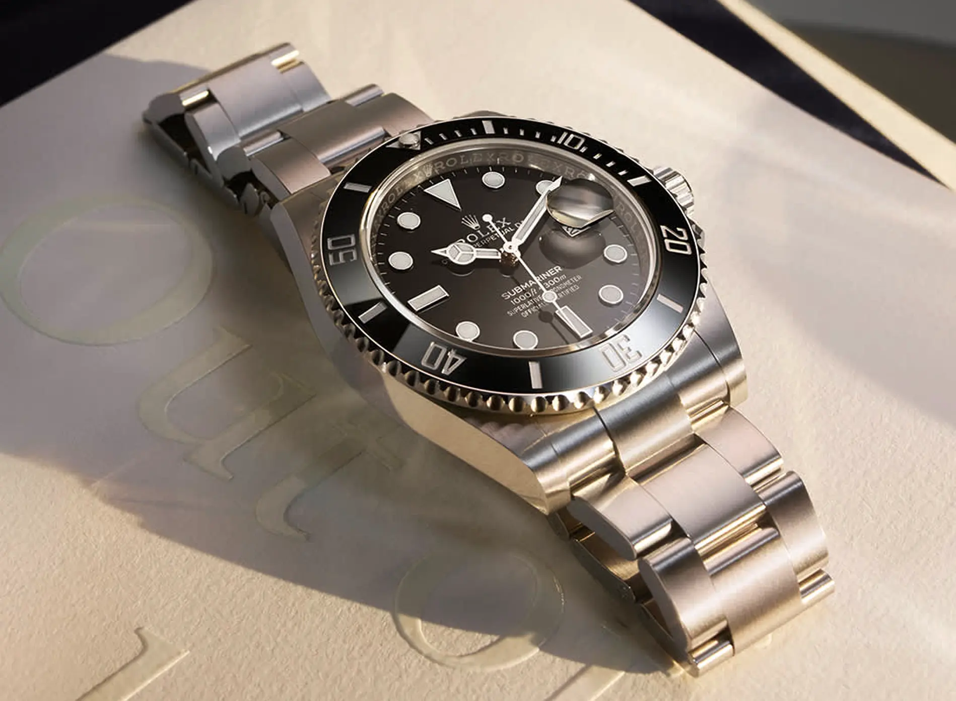 Rolex Submariner stainless steel wristwatch with black dial and bezel on a light surface.
