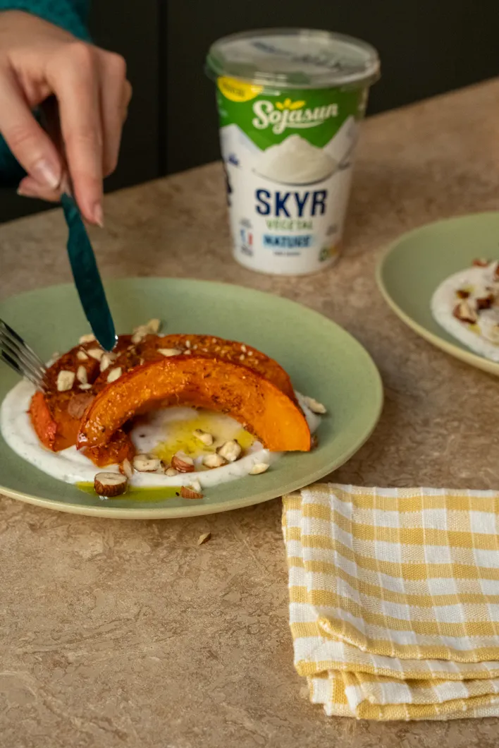 Une assiette avec de la courge rôtie et une sauce dessert nature nature épicée au zaatar